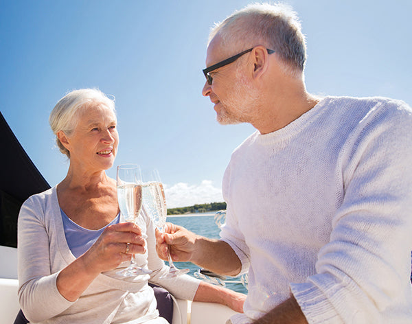 Senior couple clinking glasses on boat or yacht